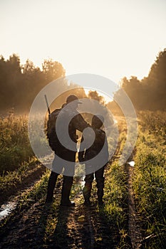 Father pointing and guiding son on first deer hunt