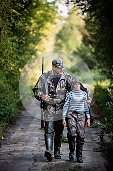 Father pointing and guiding son on first deer hunt