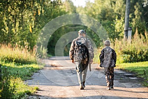 Father pointing and guiding son on first deer hunt