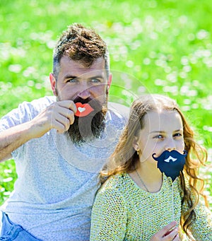 Father posing with lips and child posing with beard photo booth attribute. Gender roles concept. Family spend leisure