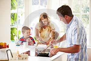 Father Preparing Family Breakfast In Kitchen