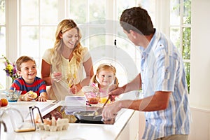 Father Preparing Family Breakfast In Kitchen