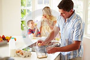 Father Preparing Family Breakfast In Kitchen