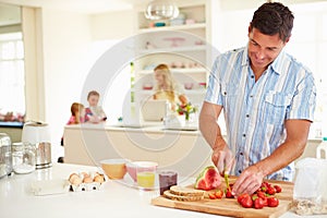 Father Preparing Family Breakfast In Kitchen