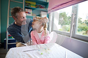 Father putting a tiera on daughters head