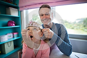 Father putting a tiera on daughters head