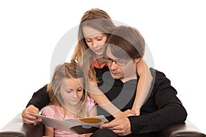 Father read a book with his â€‹â€‹daughters