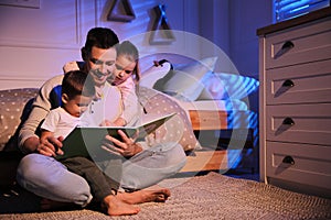 Father reading bedtime story to his children