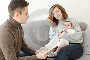 Father reading book to child and mother