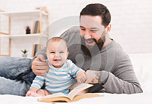 Father reading book to little baby son