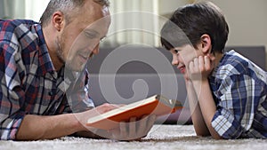 Father reading preschool child interesting story book, spending time together