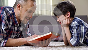 Father reading preschool child interesting story book, spending time together