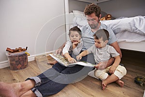 Father Reading Story To Children In Their Bedroom