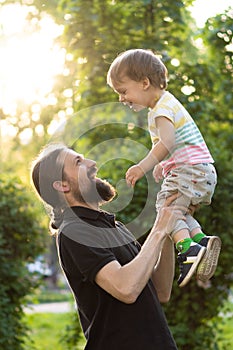 Father`s day celebration. Fatherhood, parenthood, childhood, caring, summer and leisure concept - young dad with beard