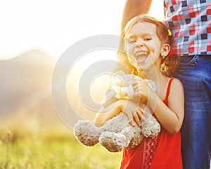 Father`s day. Child girl hugging father in nature at sunset