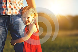 Father`s day. Child girl hugging father in nature at sunset