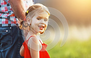 Father`s day. Child girl hugging father in nature at sunset