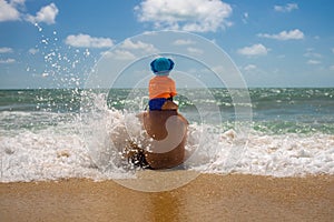 Father`s day. dad with a baby on his shoulders playing in the spray of sea foam. safe parent concept