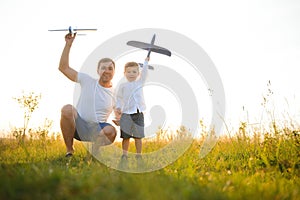 Father's day. dad and baby son playing together outdoors plane