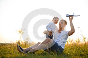 Father's day. dad and baby son playing together outdoors plane