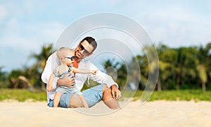 Father`s day. Dad and baby son playing together outdoors on a su