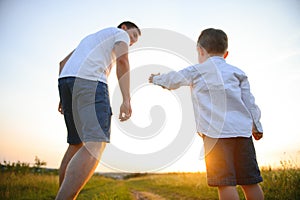 father's day. Dad and son playing together outdoors on a summer. Happy family, father, son at sunset.