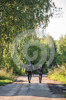 Father`s day. Father with gun showing something to son while hunting on a nature. Happy family, Fathers Day and local