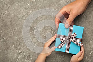 Father's day gift with daughter or son holding dad's hands giving present box to tell I love you