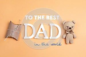 Father`s Day greeting message with toy bear and gift box on yell