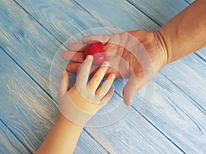 Father`s Day Hands Dad and Child giving creative holding thankful Heart on a Blue Wooden Background