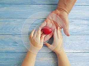 Father`s Day Hands Dad and Child giving greeting creative holding thankful Heart on a Blue Wooden Background