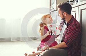 Father`s day. Happy family daughter giving dad greeting card