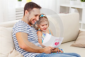 Father`s day. Happy family daughter giving dad greeting card