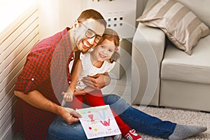 Father`s day. Happy family daughter giving dad greeting card