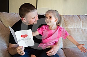 Father`s day. Happy family daughter giving dad a greeting card on holiday