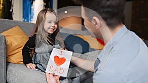 Father's day. Happy family daughter giving dad a greeting card on holiday