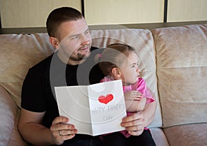 Father`s day. Happy family daughter giving dad a greeting card on holiday