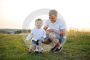 Father's day. Happy family father and toddler son playing and laughing on nature at sunset