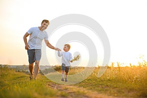 Father's day. Happy family father and toddler son playing and laughing on nature at sunset