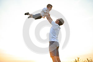 Father's day. Happy family father and toddler son playing and laughing on nature at sunset