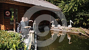 father's day. person with disability. dad and his little cute son are visiting the Zoo, walking together on summer day