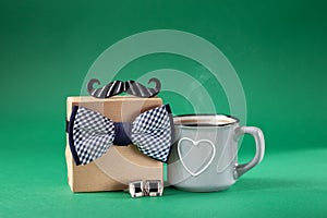 Father`s day present gift box with mug coffee on green background.Holiday present concept