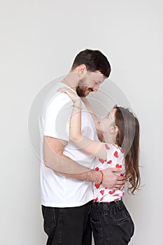 father& x27;s day. side view affectionate little child daughter is hugging smiling bearded father. Happy small kid girl