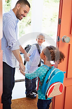 Father Saying Goodbye To Children As They Leave For School