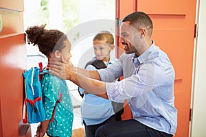 Father Saying Goodbye To Children As They Leave For School