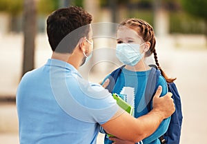 Father saying goodbye to daughter near school