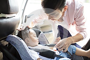 Father securing baby in the car seat