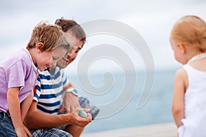 Father showing caught fish to kids