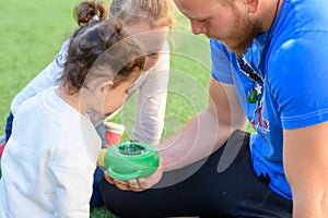 The father shows the caterpillar to the children