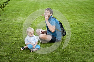 Father shows his son how to blow soap bubbles